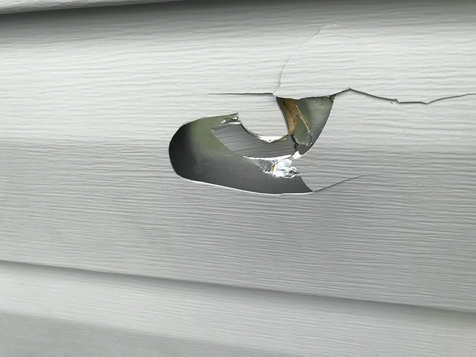 Exterior House Vinyl Siding Damage Showing Hole