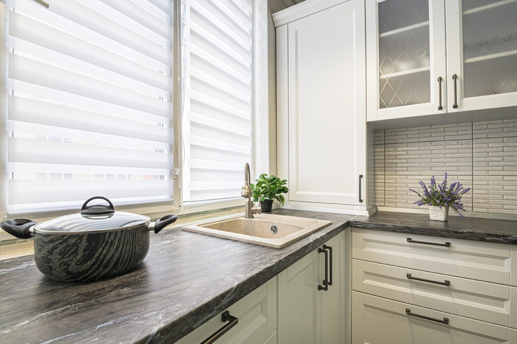 simple well designed modern white kitchen interior. Modern Kitchen Blinds covering new window.